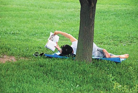 	한 남성이 잔디밭에 누워 책을 읽고 있다./사진=조선일보 DB
