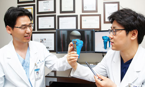 	바른본병원 안형권(왼쪽) 병원장과 고택수 원장이 3D 프린터로 만든 환자의 무릎 모형을 보면서 수술할 방향과 위치, 각도 등에 대해 논의