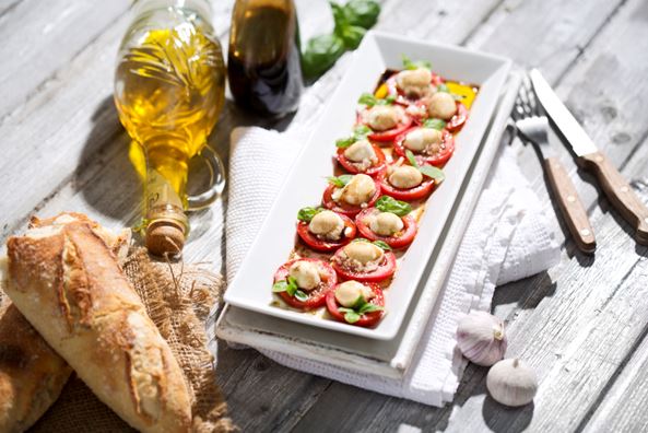 바게트, 올리브유, 토마토 카나페가 테이블에 올려져 있다
