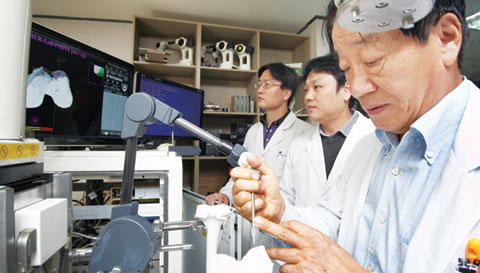 이춘택 원장(오른쪽)이 로봇관절연구소에서 로봇의 수술각도 등을 점검하고 있다. 