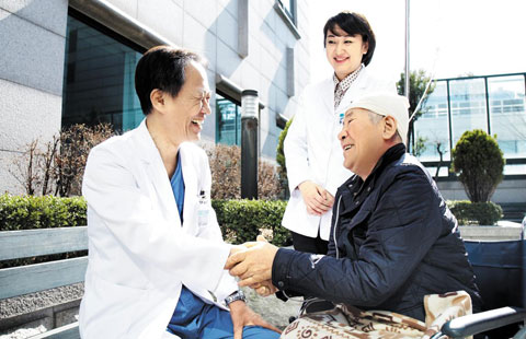 분당제생병원 뇌종양클리닉 김한규(왼쪽) 교수는 뇌의 정상조직은 건드리지 않으면서 종양을 제거하는 ‘달팽이관 라인’ 수술법을 개발해 세계적인 주목을 받았다. 사진은 김교수에게서 뇌종양 수술을 받은 곽성남(71)씨가 김교수와 함께 산책을 하는 모습.