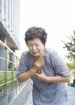 한 여성이 가슴에 통증을 호소하고 있다