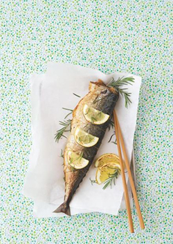 레몬과 로즈마리가 올려진 생선 구이가 접시 위에 놓여 있다