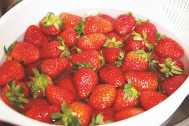 바가지에 물과 함께 딸기가 담겨 있다.