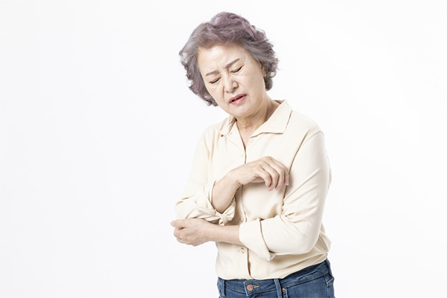 팔꿈치 아파하는 노인 여성