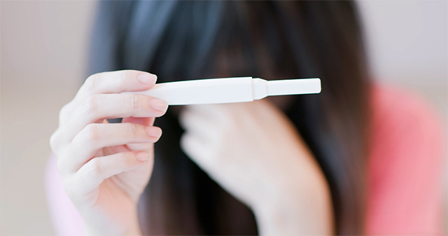 여성이 임신테스트기를 들고 좌절하고 있다