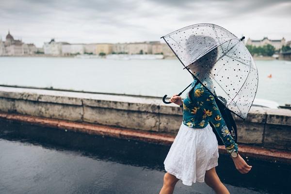 빗속에서 우산 쓰고 걸어가는 여성