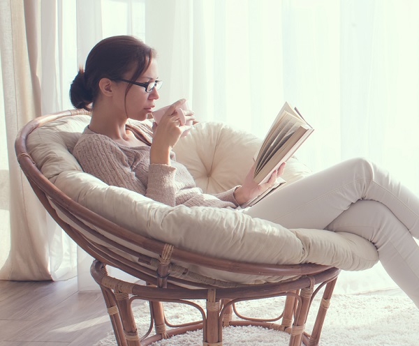 의자에 앉아서 신문읽는 여성
