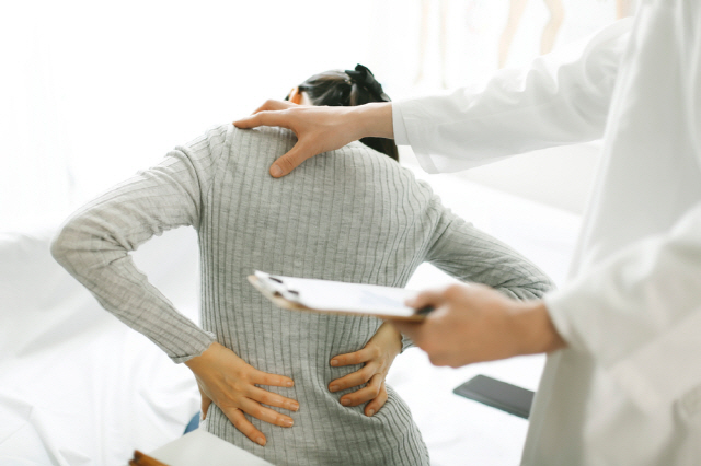 허리 아파하는 여성과 의사