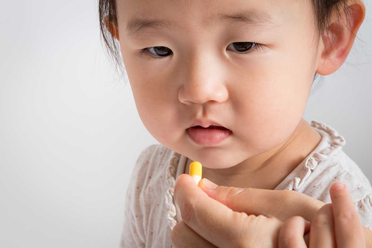 아이에게 약을 먹이려는 손