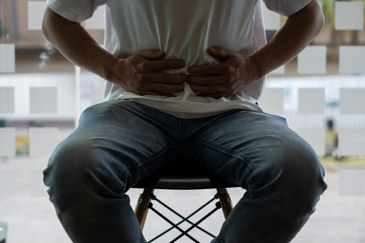 배를 잡고 있는 남성