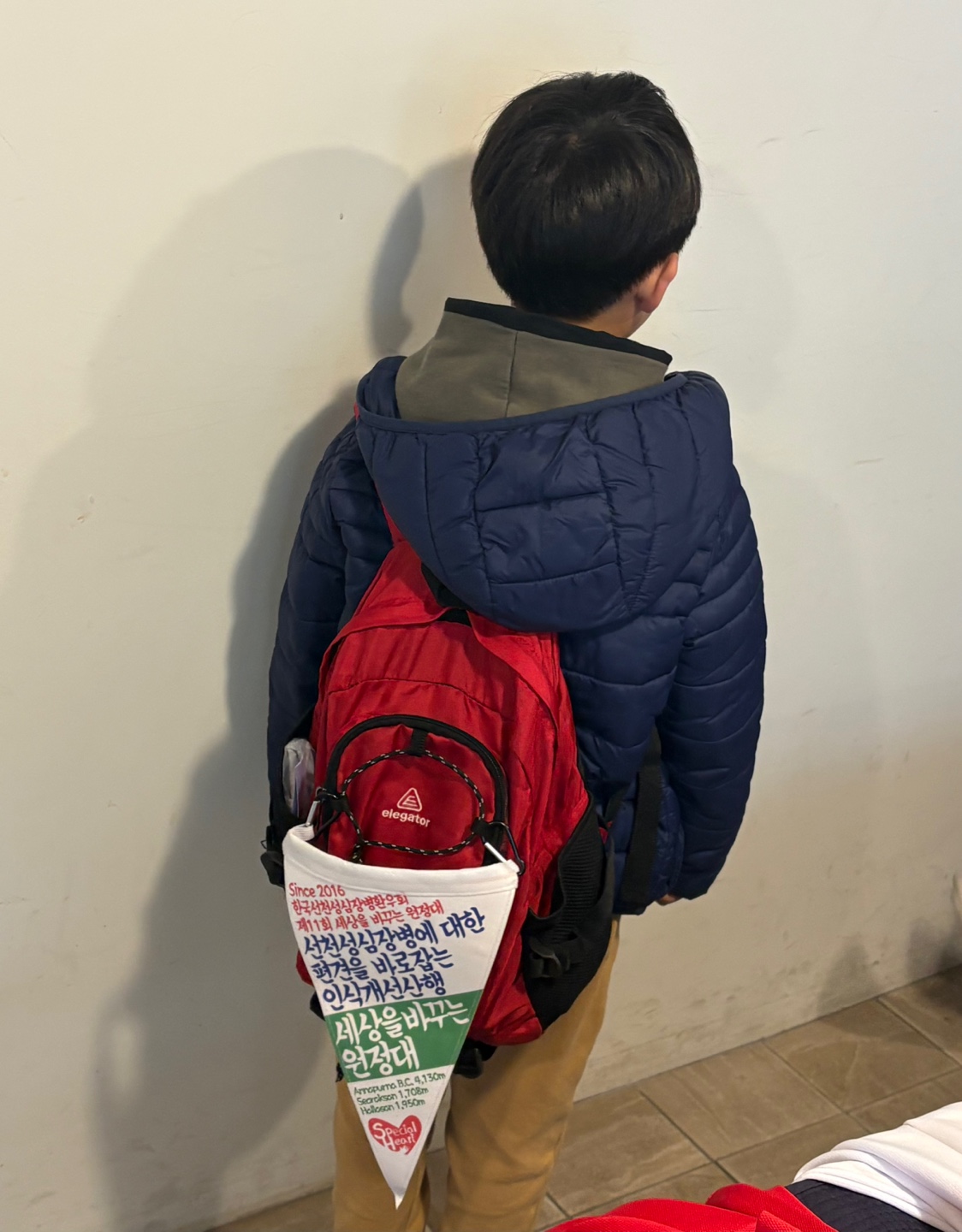 슬로건 깃발을 가방에 단 아이