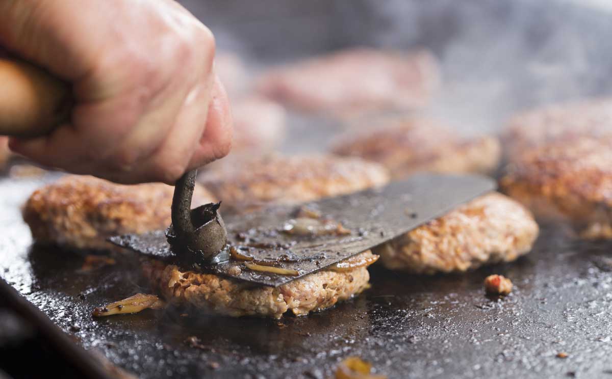 철판 위에서 조리되고 있는 햄버거 패티